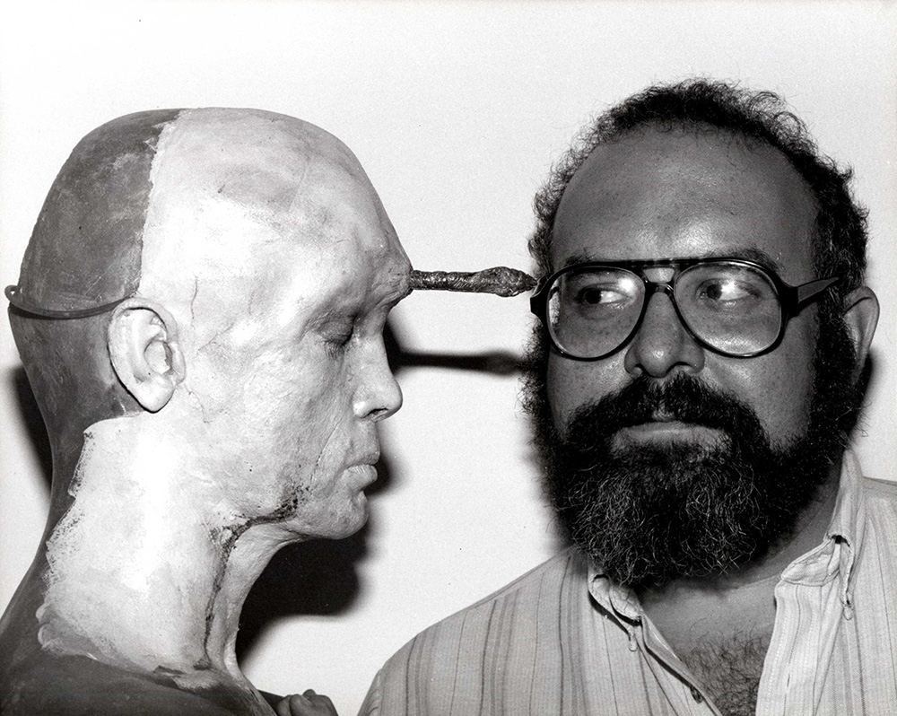 Stuart Gordon right looking at spiked prop head left.