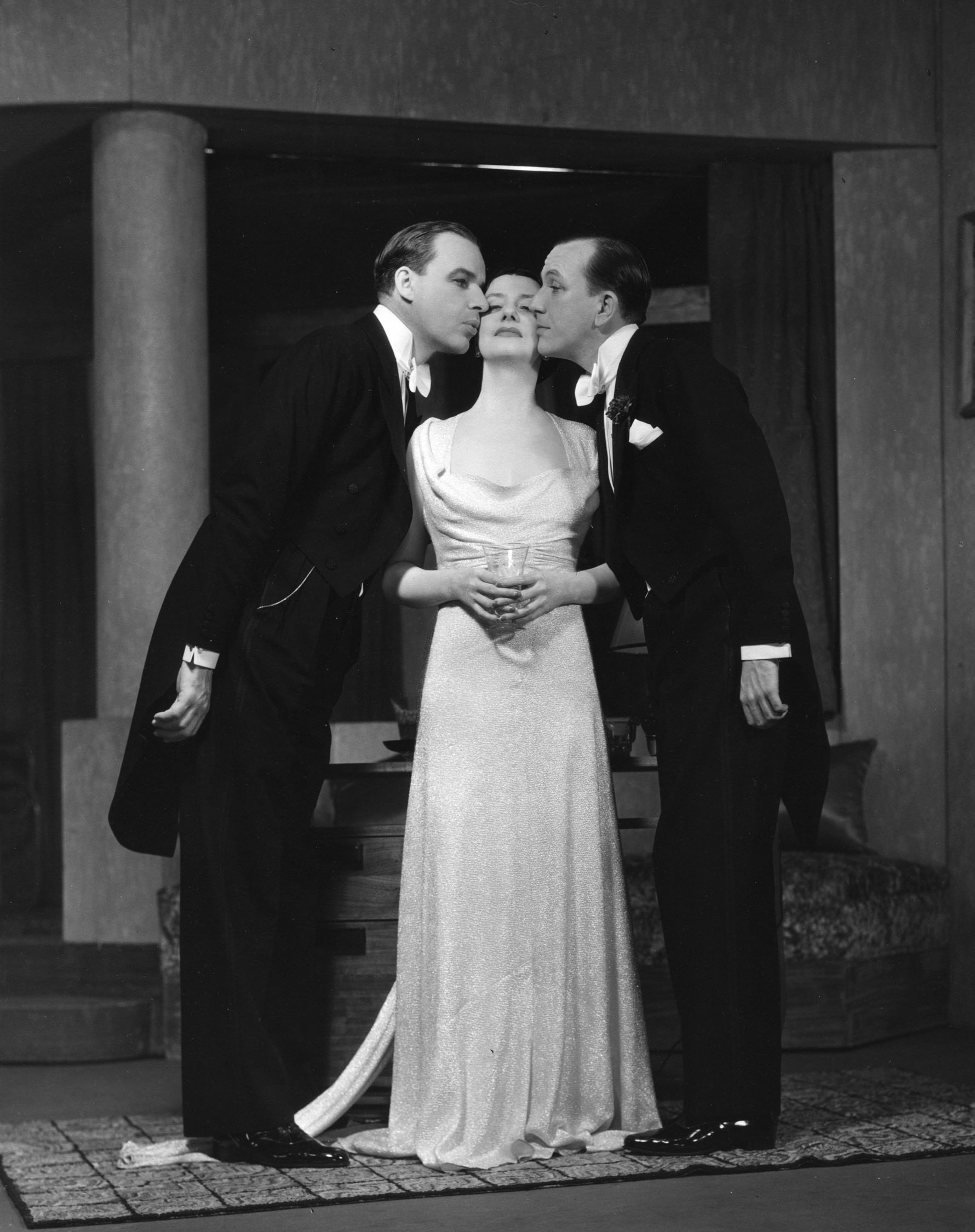 Alfred Lunt (Otto) and Noël Coward (Leo) kiss Lynn Fontanne (Gilda).