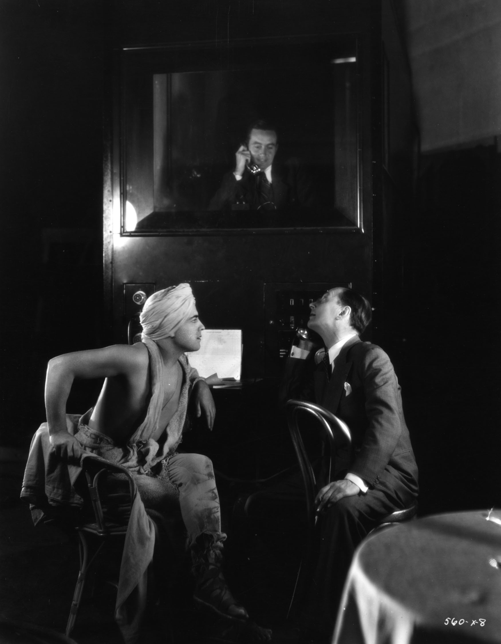 Director Jacques Feyder and star Ramon Novarro on the set of the 1931 early sound feature Son of India (originally titled "Son of Rajah"). Original caption reads, "From his sound proof portable booth, via a horn on top of it, the 'mixer' tells star Ramon Novarro and director Jacques Feyder what he thought of the quality of dialogue in the previous scene of Novarro’s new M-G-M picture, 'Son of Rajah.'"